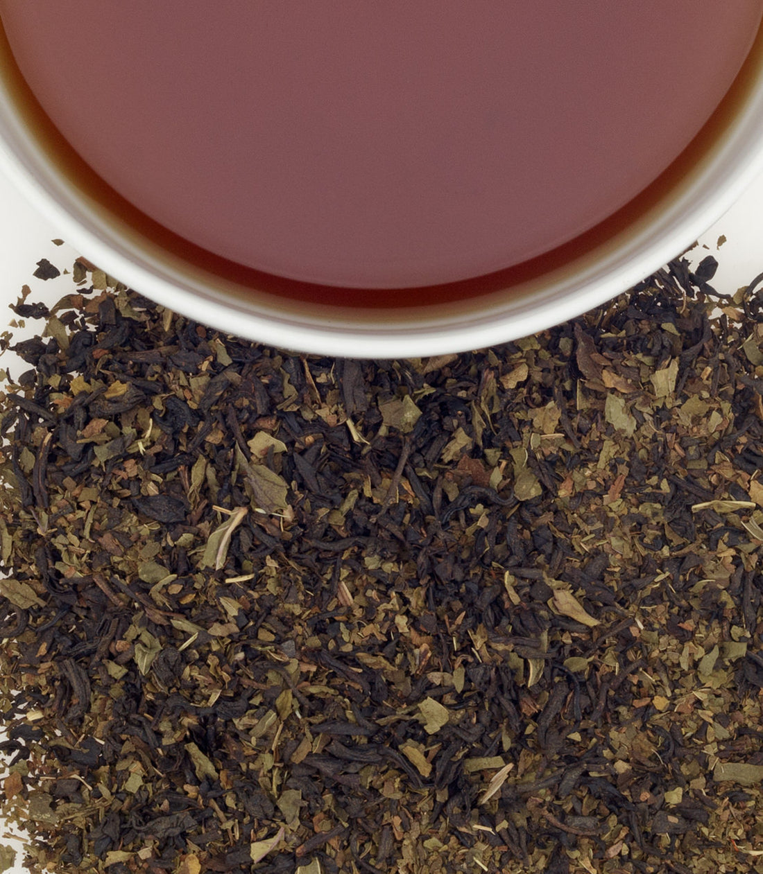 Close up of loose chocolate mint tea by harney and sons with a cup of brewed tea